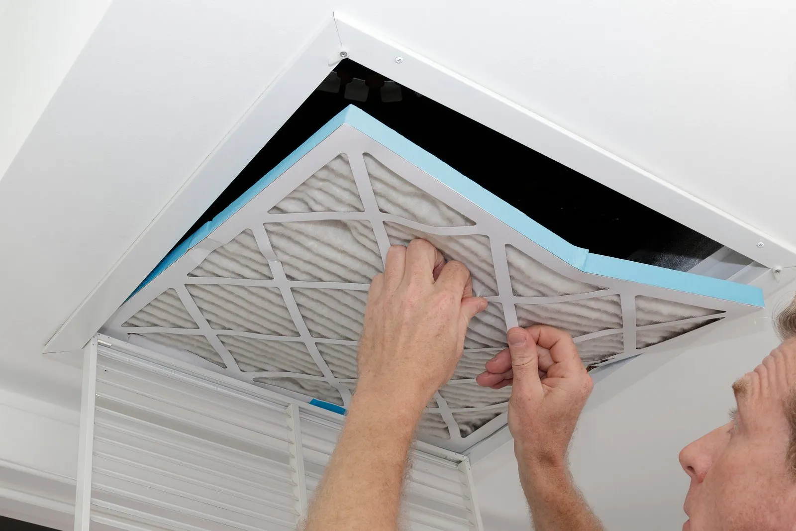 Technician cleaning an air duct vent in a Houston home
